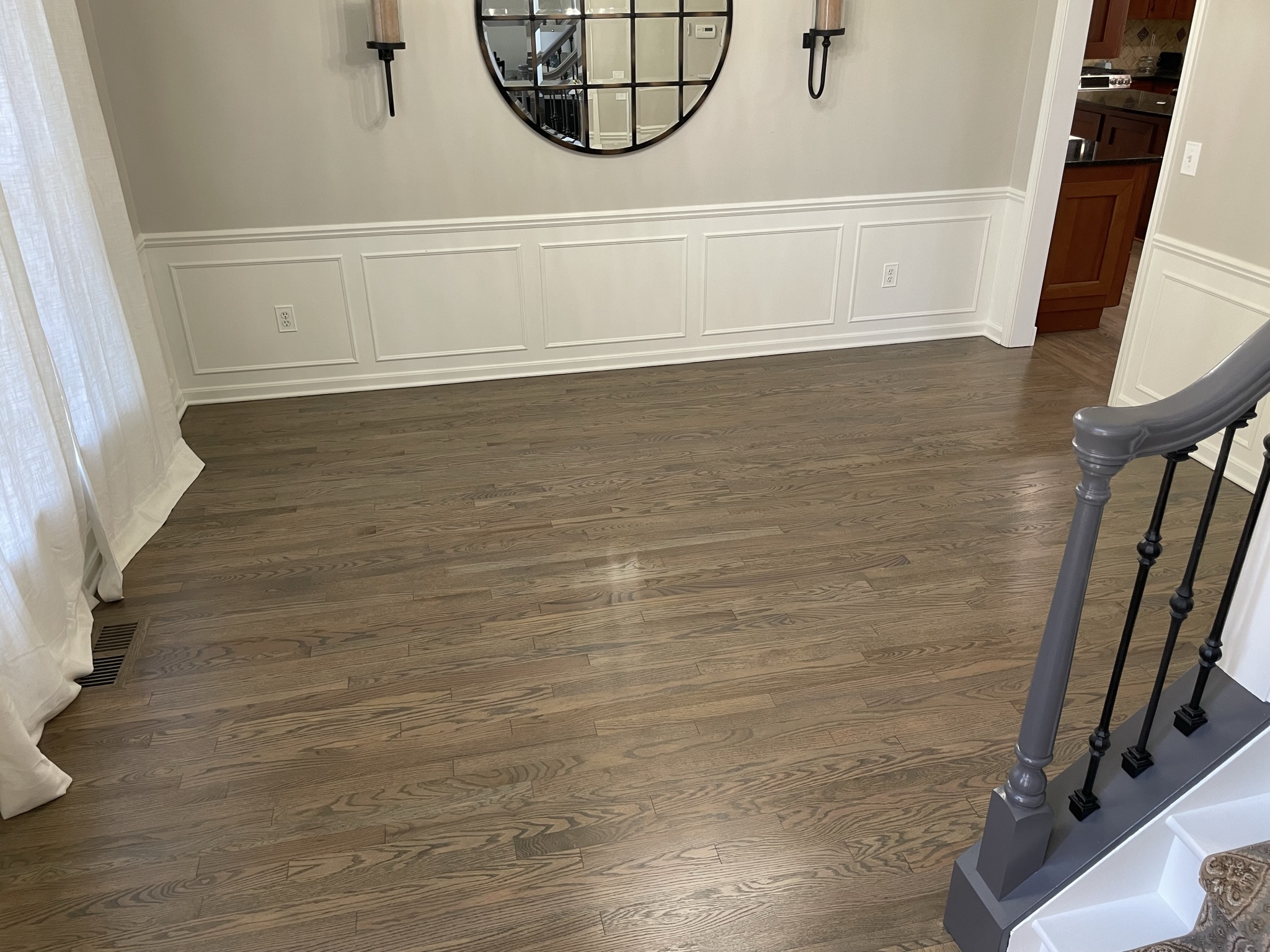 Refinished hardwood flooring extending through a stair and living area